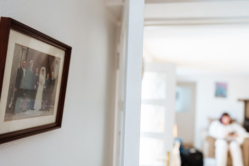 Framed photograph on white wall with blurred living room in background.
