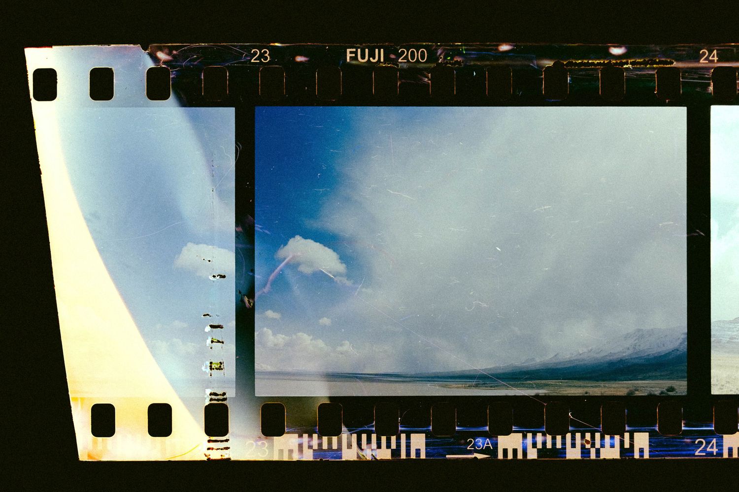 Film strips showing landscape photography with mountains and clouds in the background.
