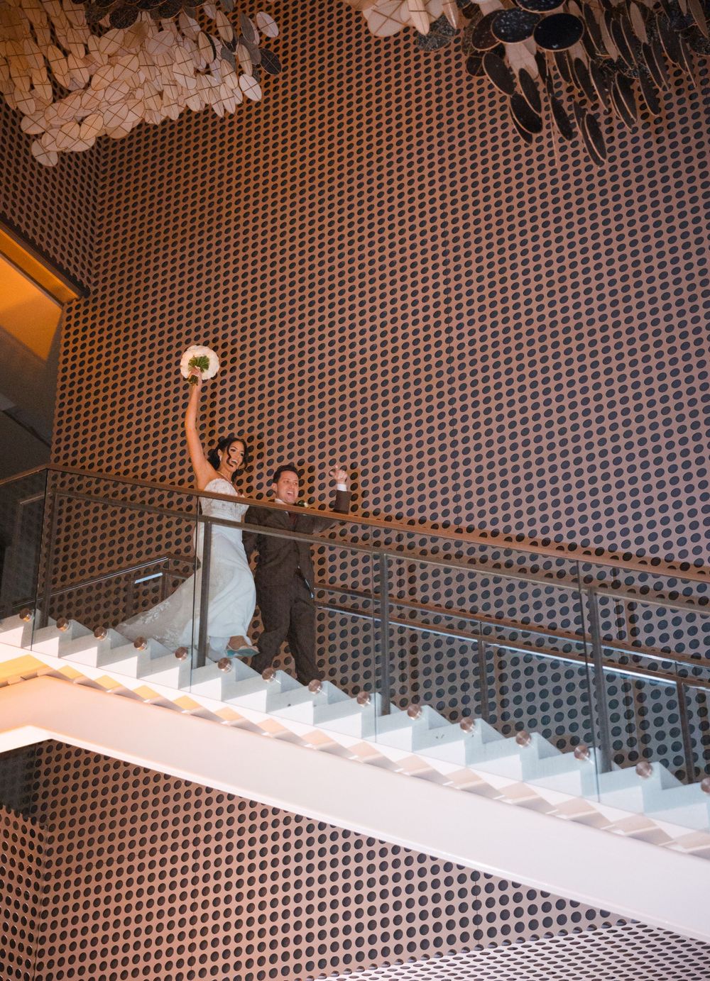 Modern white staircase with perforated metallic wall design creates a striking architectural pattern.