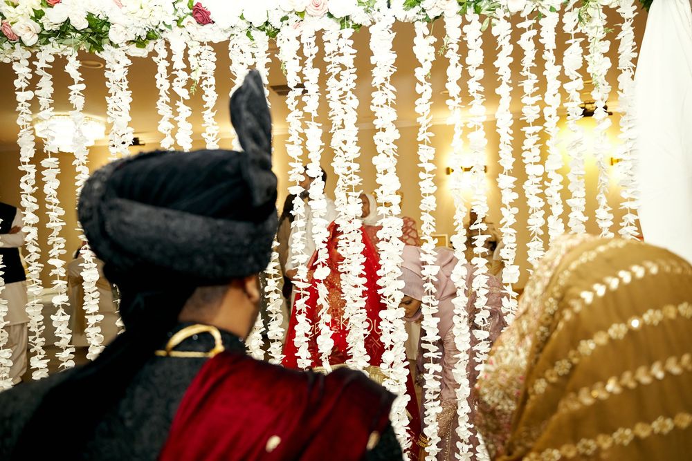 Gold sequined curtains sparkle with holiday decorations and lights creating a festive background display. at Antuns by Minar