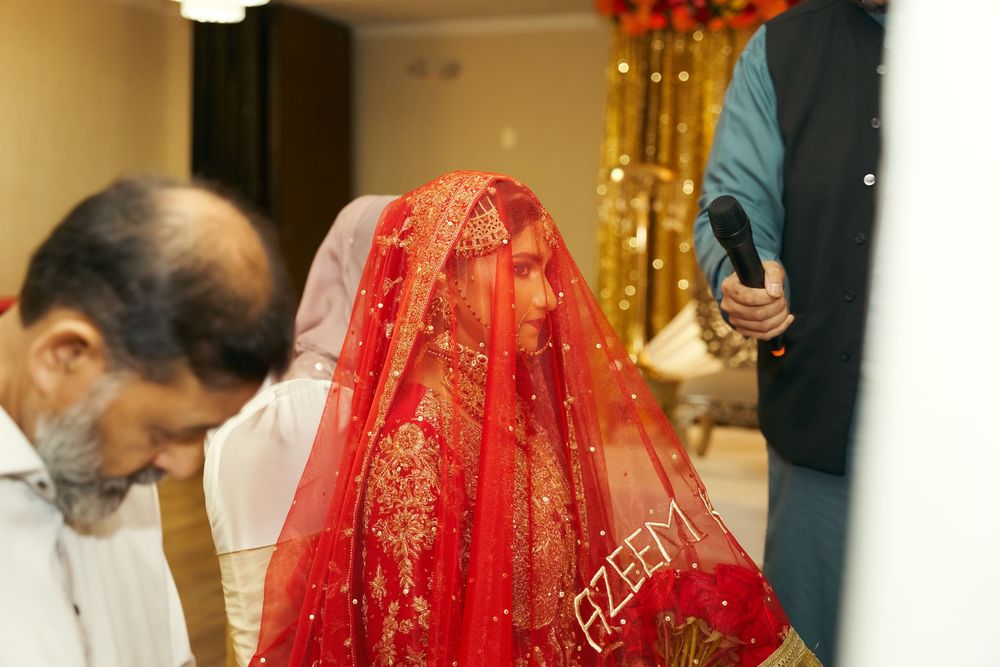 A traditional South Asian wedding ceremony with the bride wearing a vibrant red and gold embroidered veil. at Antuns by Minar