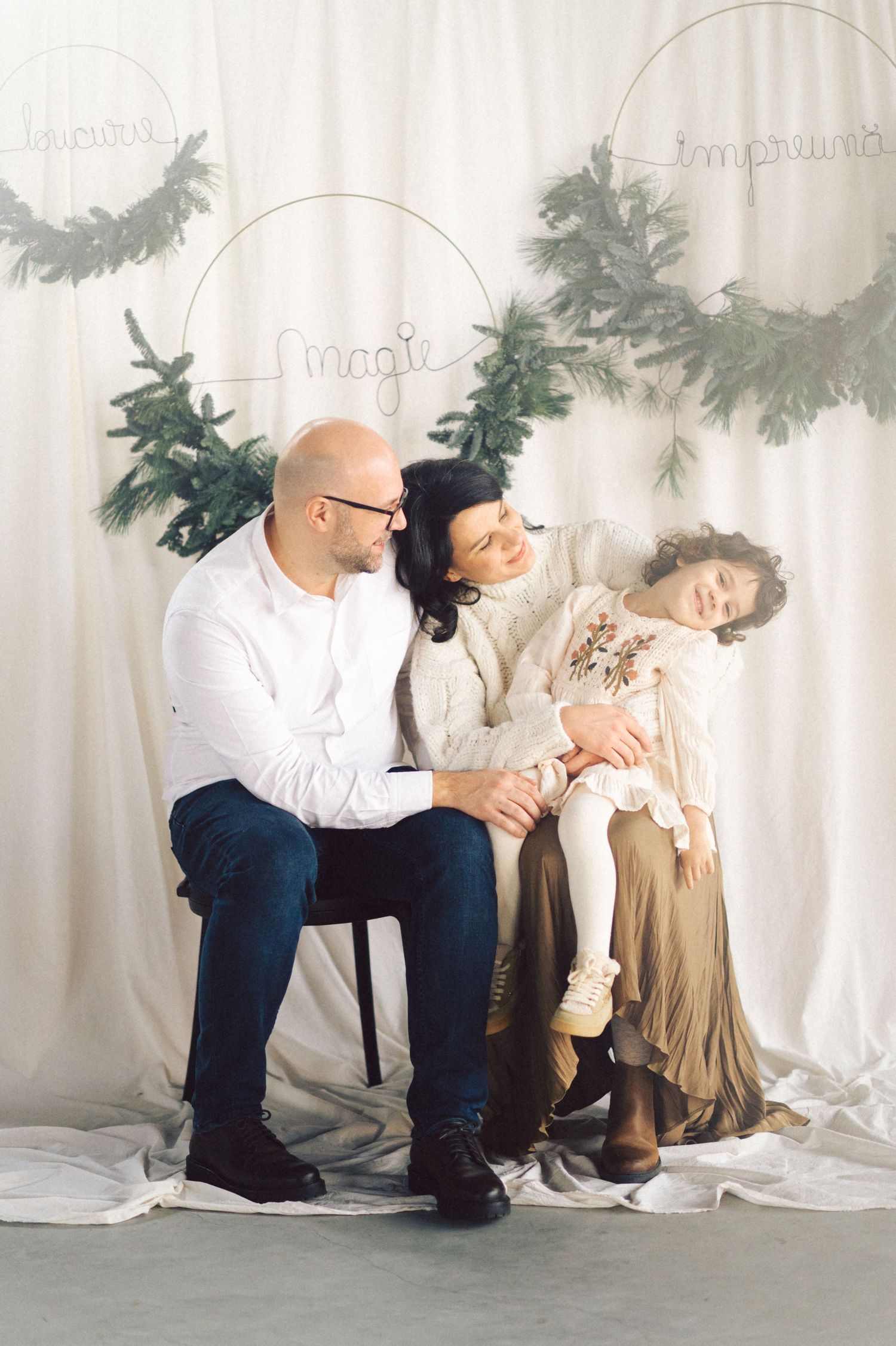 Four artistic photos showing a couple's playful interaction during a white studio photoshoot session.