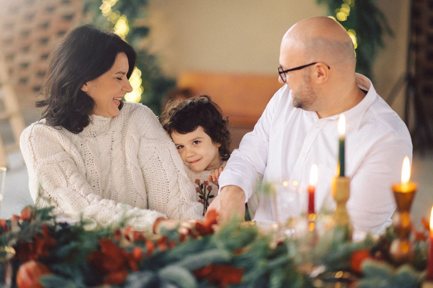 Couple embracing and laughing together during romantic holiday celebration with festive decor.