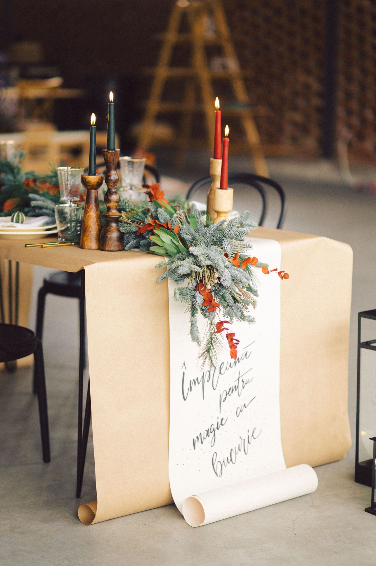 Elegant winter wedding place cards with pine greenery and berries decorated in calligraphy on cream-colored paper.