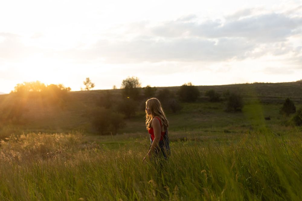 Sunset photography session in a golden field with mountains on the horizon.