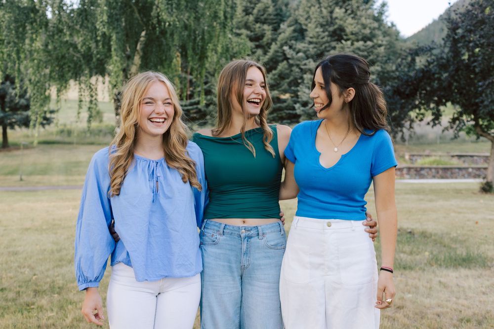 Group photo of friends wearing coordinated blue and white outfits in an outdoor setting.