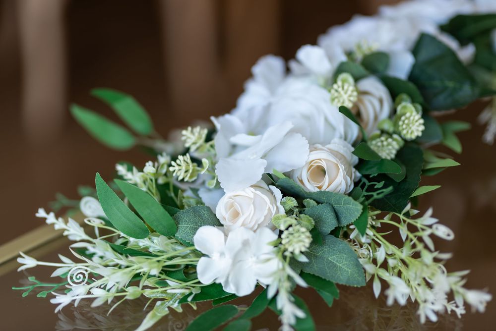 White floral arrangements with roses and greenery displayed for a wedding.