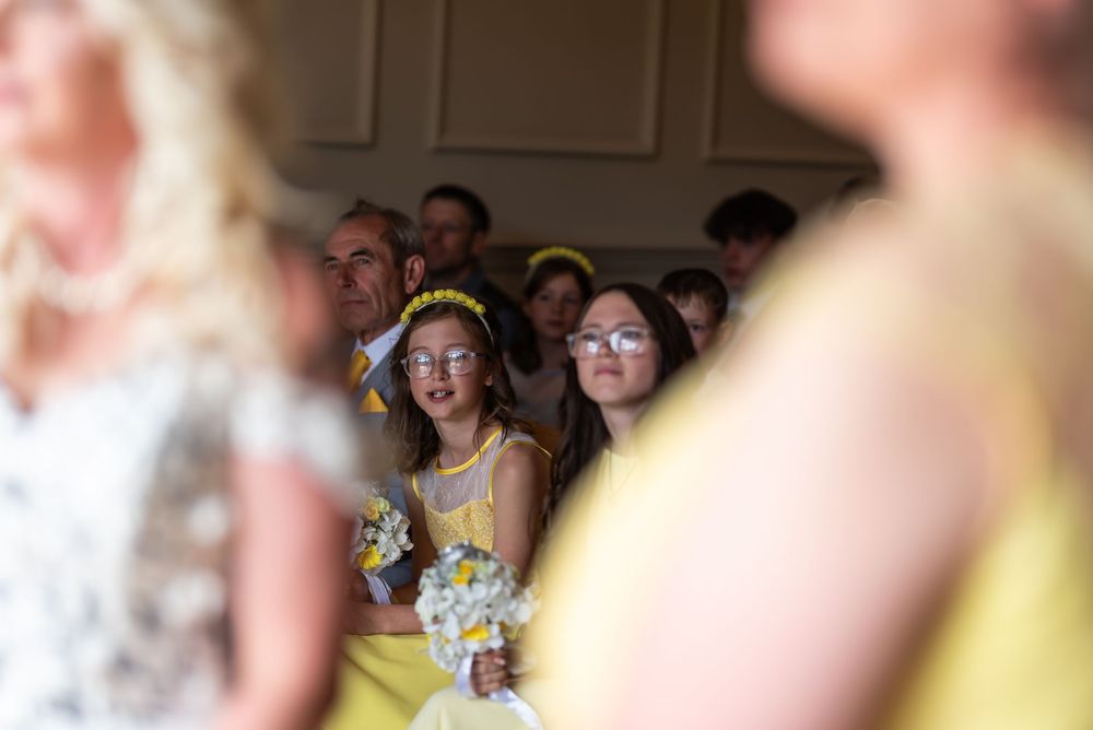 Bridesmaids in yellow dresses smiling during wedding celebrations.