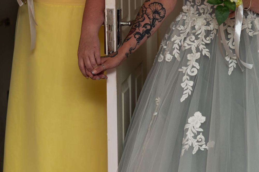 Detail shot of yellow bridesmaid dresses and white lace gown.