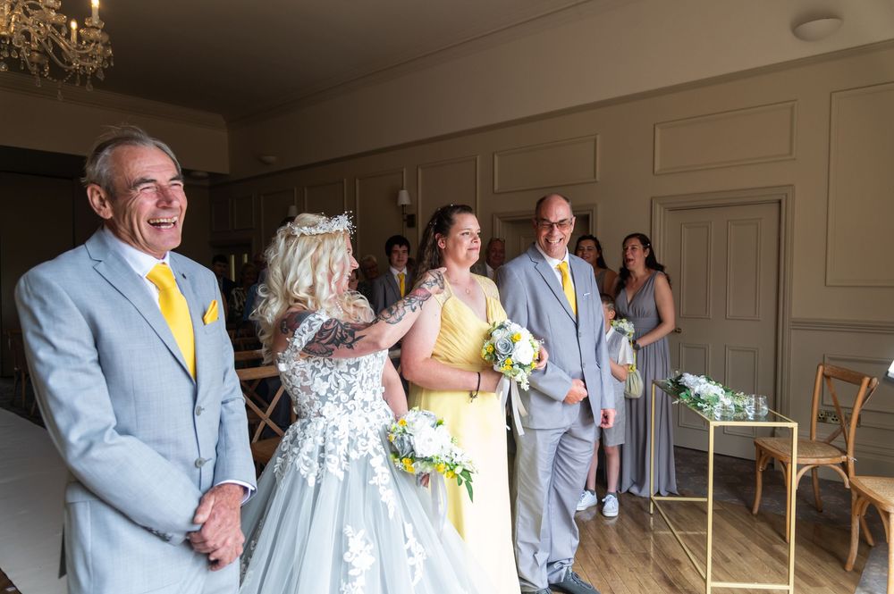 Wedding celebration with attendees in formal attire mingling in an elegant indoor setting.