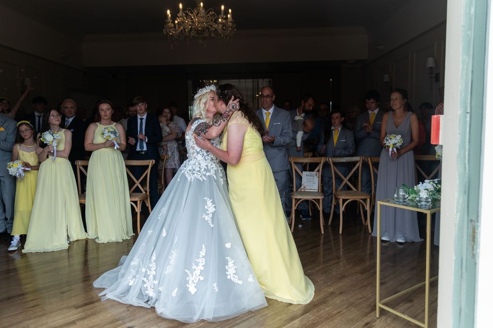 Elegant wedding reception venue with chandelier and guests in formal attire.