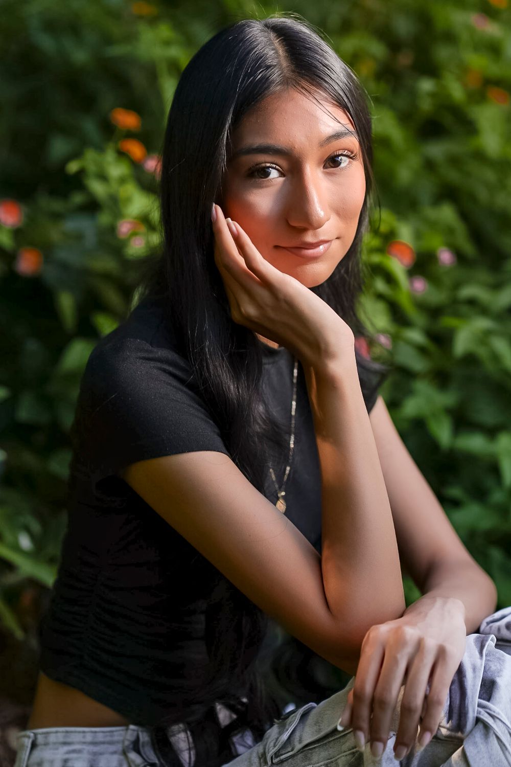 A series of candid outdoor portraits showing someone in a black top against a green garden background with orange flowers.