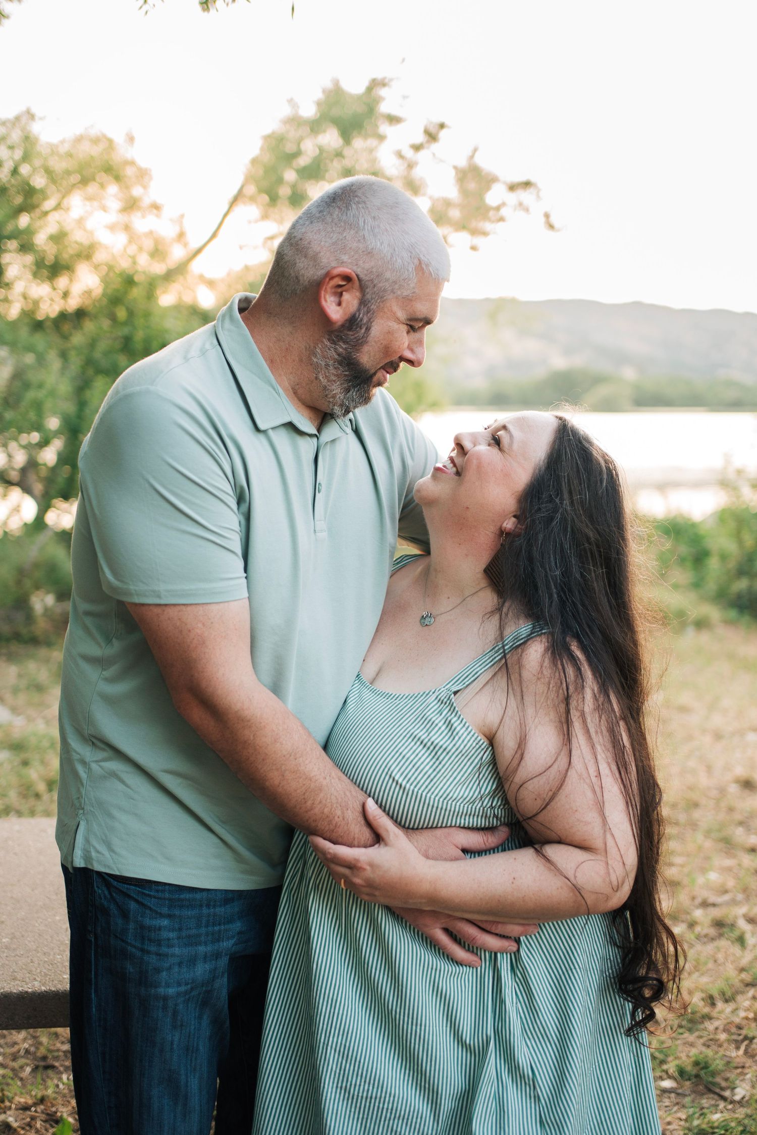 Husband and wife hold each other while gazing in each others eyes