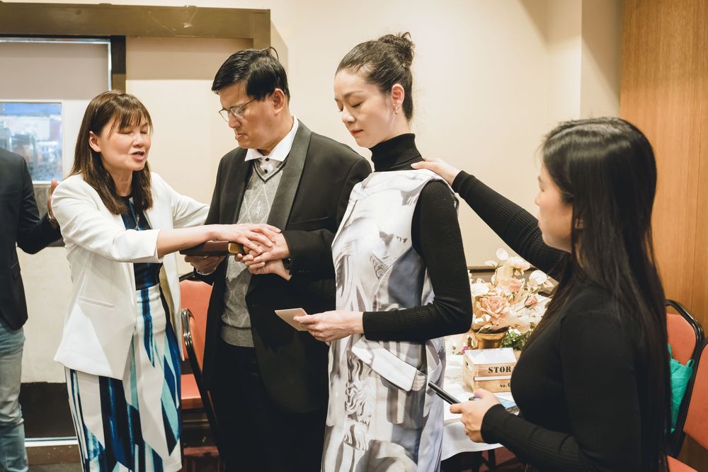 Business professionals networking and shaking hands at a professional event in a conference room.