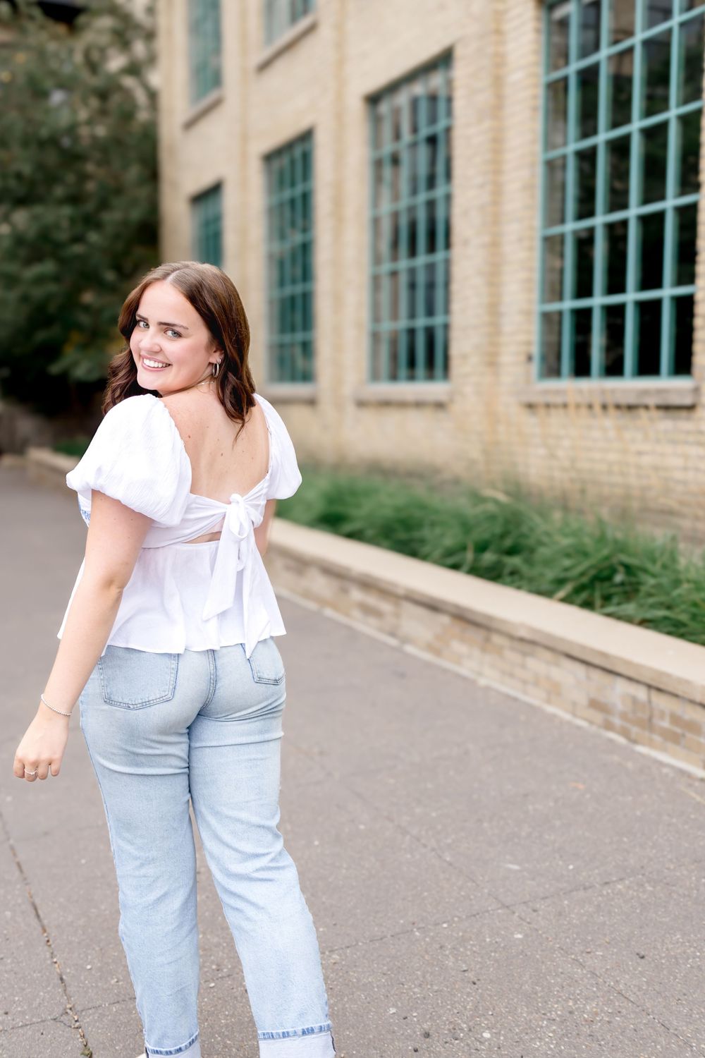 Casual movement shots along concrete pathway by vintage brick building.