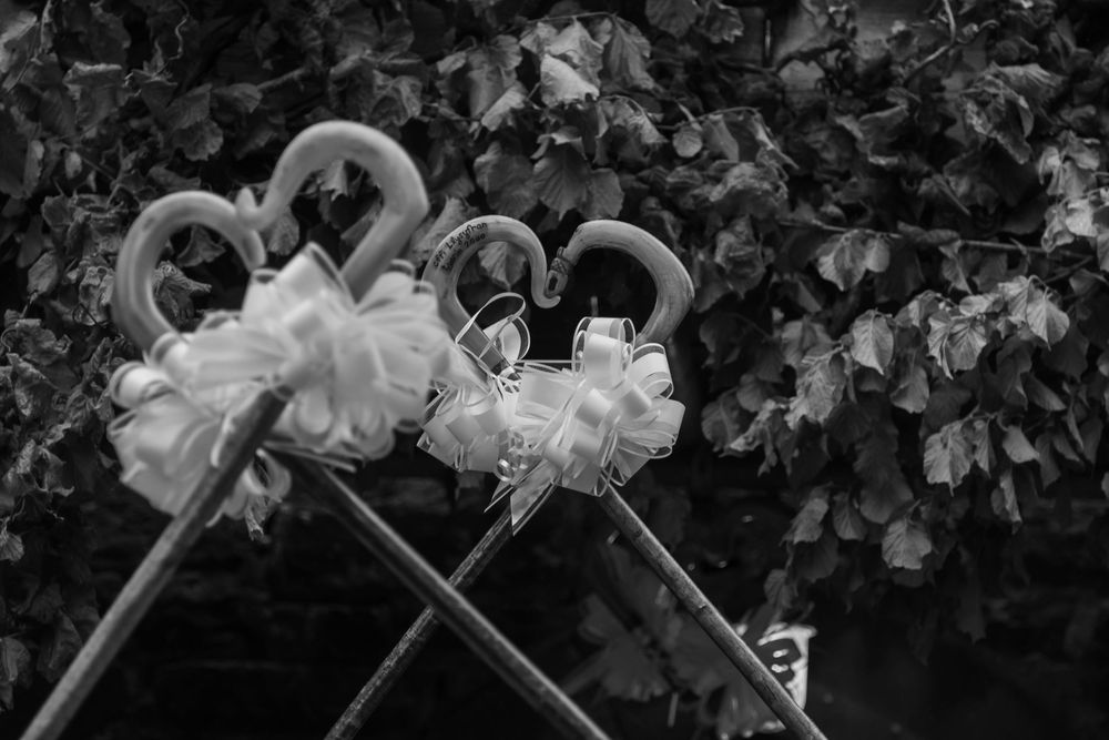 Decorative white ribbon and floral arrangements adorn dark background.