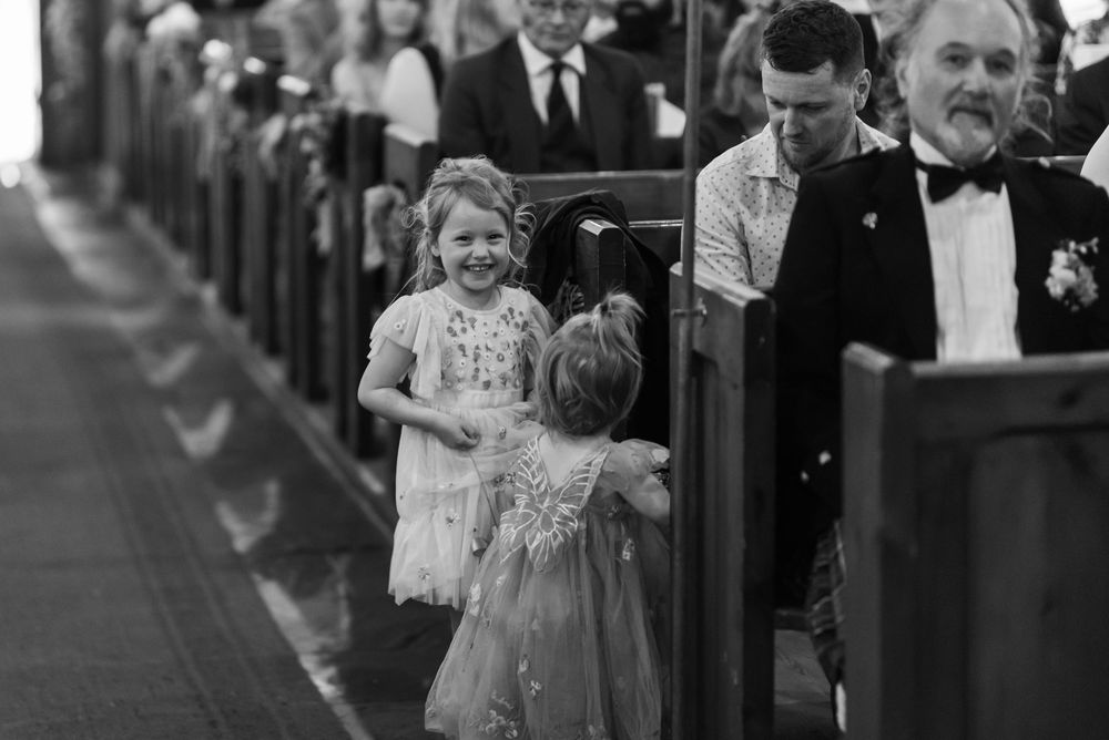 Black and white photo of wedding guests during ceremony celebrations.