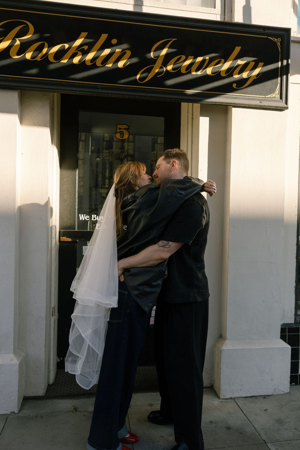A romantic moment outside Rocklin Jewelry store with a flowing white veil in the scene.
