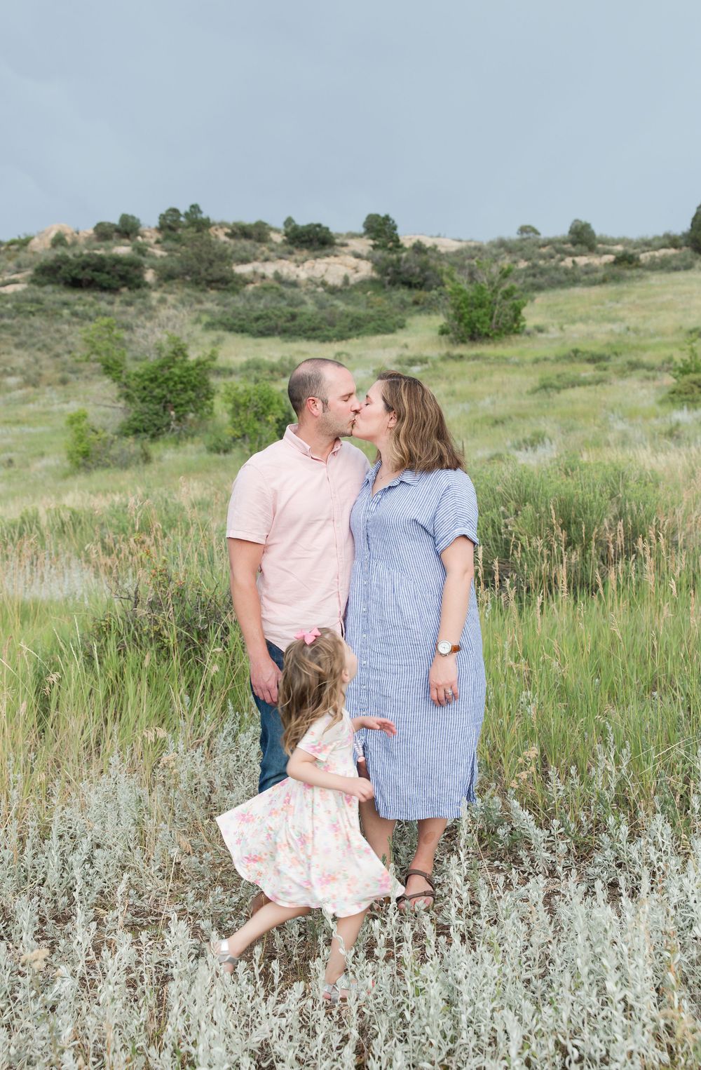 Family sharing tender moments together in a meadow of sage brush during golden hour.