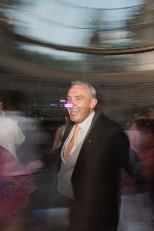Motion blur photograph showing people dancing and celebrating in what appears to be a festive indoor party setting.