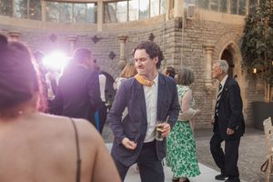 Wedding guests dancing and socializing at an outdoor brick venue with natural lighting and architectural details.