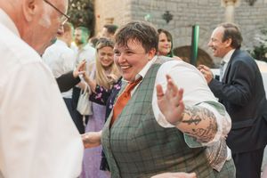 A celebratory crowd at a wedding reception dancing and enjoying themselves on the dance floor.