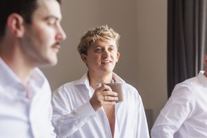 Two people in white shirts having a relaxed conversation by a window in natural light.