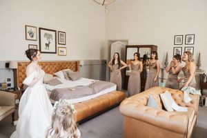 Luxurious bedroom suite decorated in neutral tones with tufted headboard and plush bedding for a wedding morning.