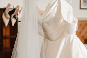 White wedding dress details with soft flowing fabric and lace textures in natural light.