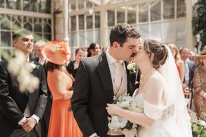 Wedding celebration in a stunning glass-roofed conservatory with guests enjoying the festivities.