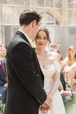 Couple sharing intimate moments during their wedding ceremony surrounded by guests.