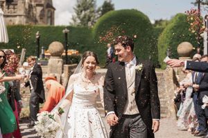 Wedding celebration in a beautiful garden setting with guests walking along stone pathways.