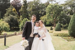 Wedding party poses in a lush garden setting on a sunny afternoon.
