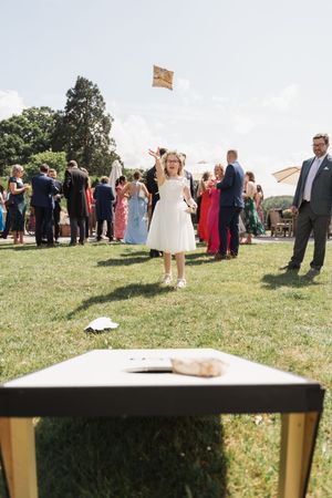 Wedding guests mingle on a grassy lawn during an outdoor reception.