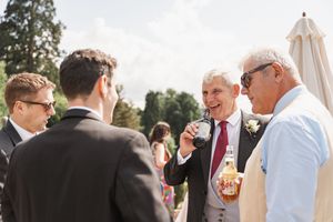 Wedding guests enjoying drinks and conversation during an outdoor reception.