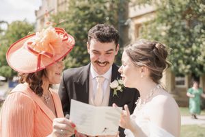 Wedding party celebrating and mingling outdoors on a sunny summer afternoon.