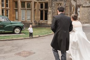 Couple walking together along the stone exterior of a historic building.