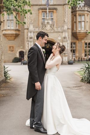 Wedding portraits captured outside a grand stone mansion with elegant architecture.