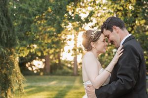 A romantic sunset moment captured between newlyweds in a lush garden setting.