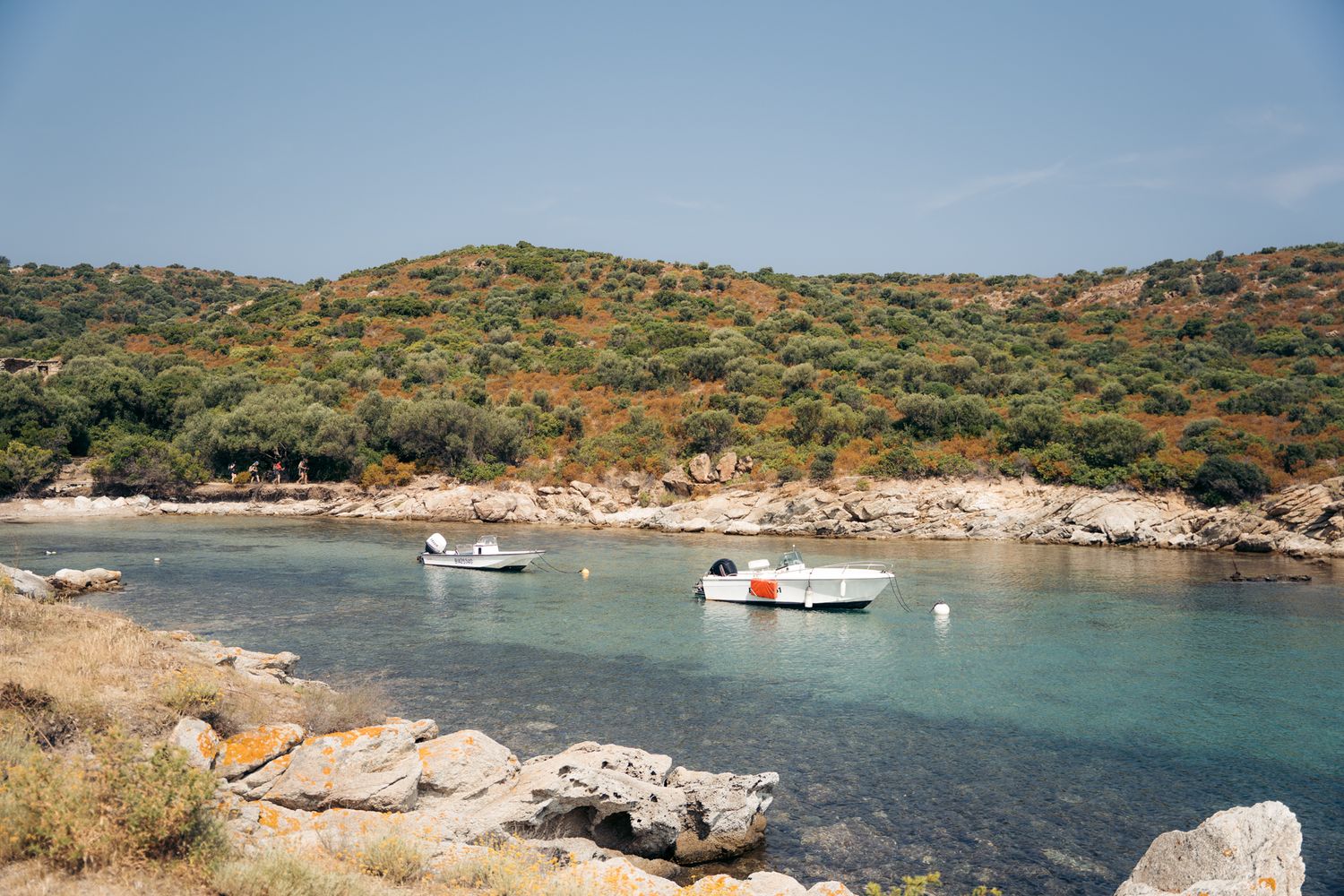 crique dans le désert des agriates avec petits bateaux et eau turquoise
