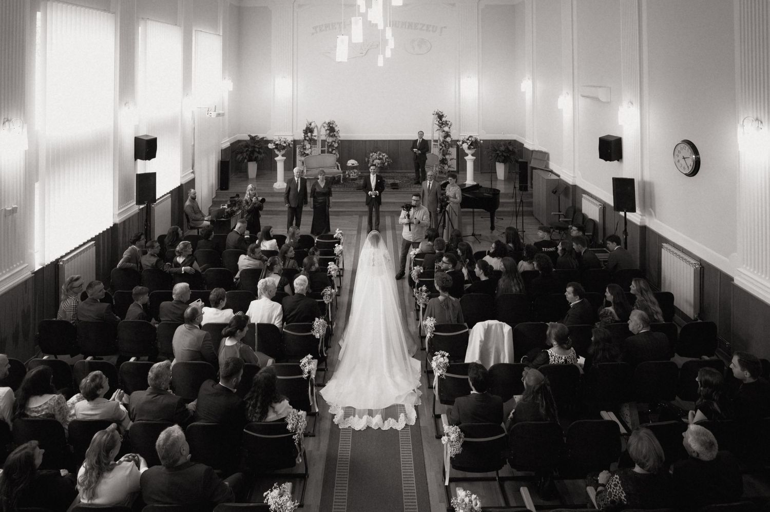 Black and white aerial view of a wedding ceremony in a church with bride walking down the aisle.