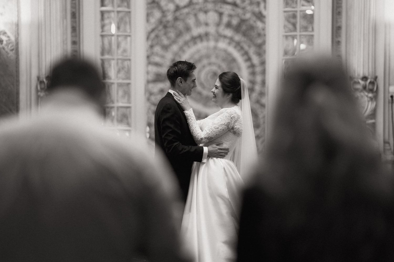 Black and white photo of a bride and groom sharing a romantic moment during their wedding ceremony.