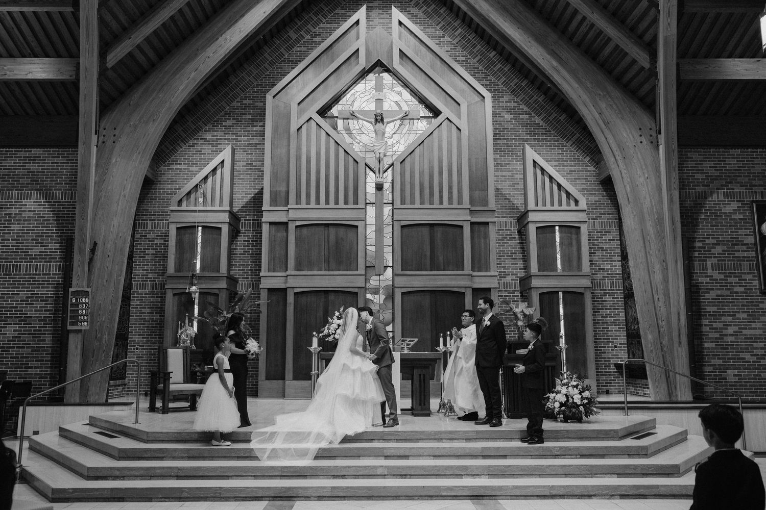 Blurred motion shot of bride and groom walking in wedding attire on green grass.