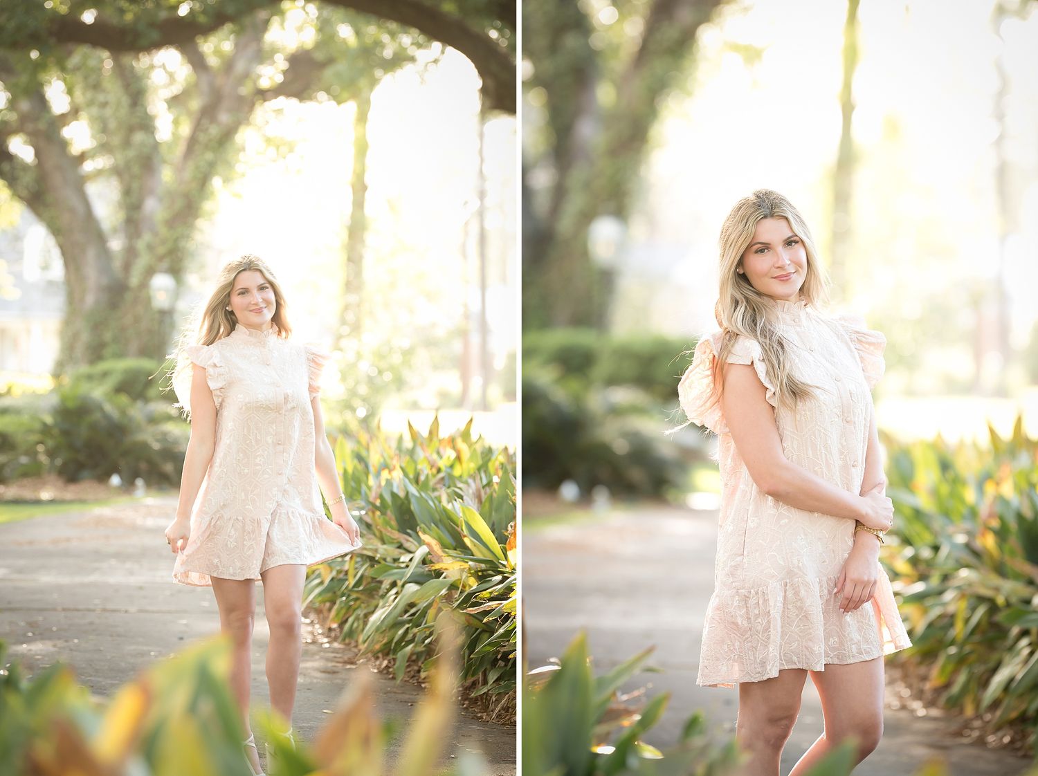 Young blonde woman in white lace dress poses gracefully in a sunlit park with lush greenery and trees.