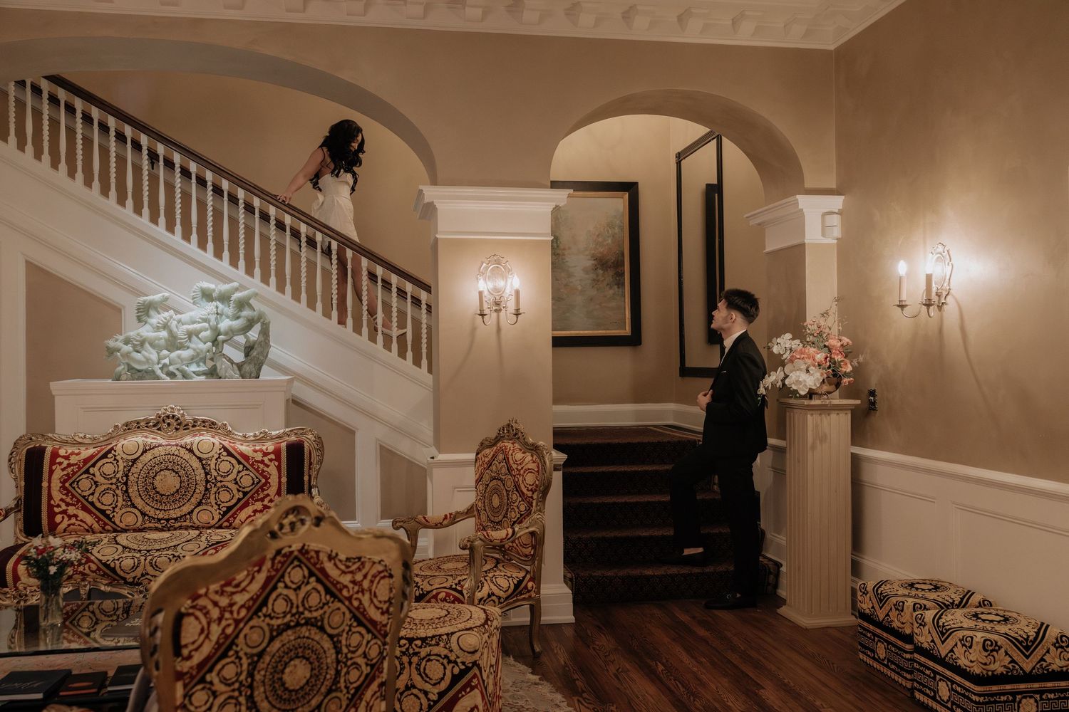 Bride walking down stairs to groom at the Inn on Broadway in Rochester