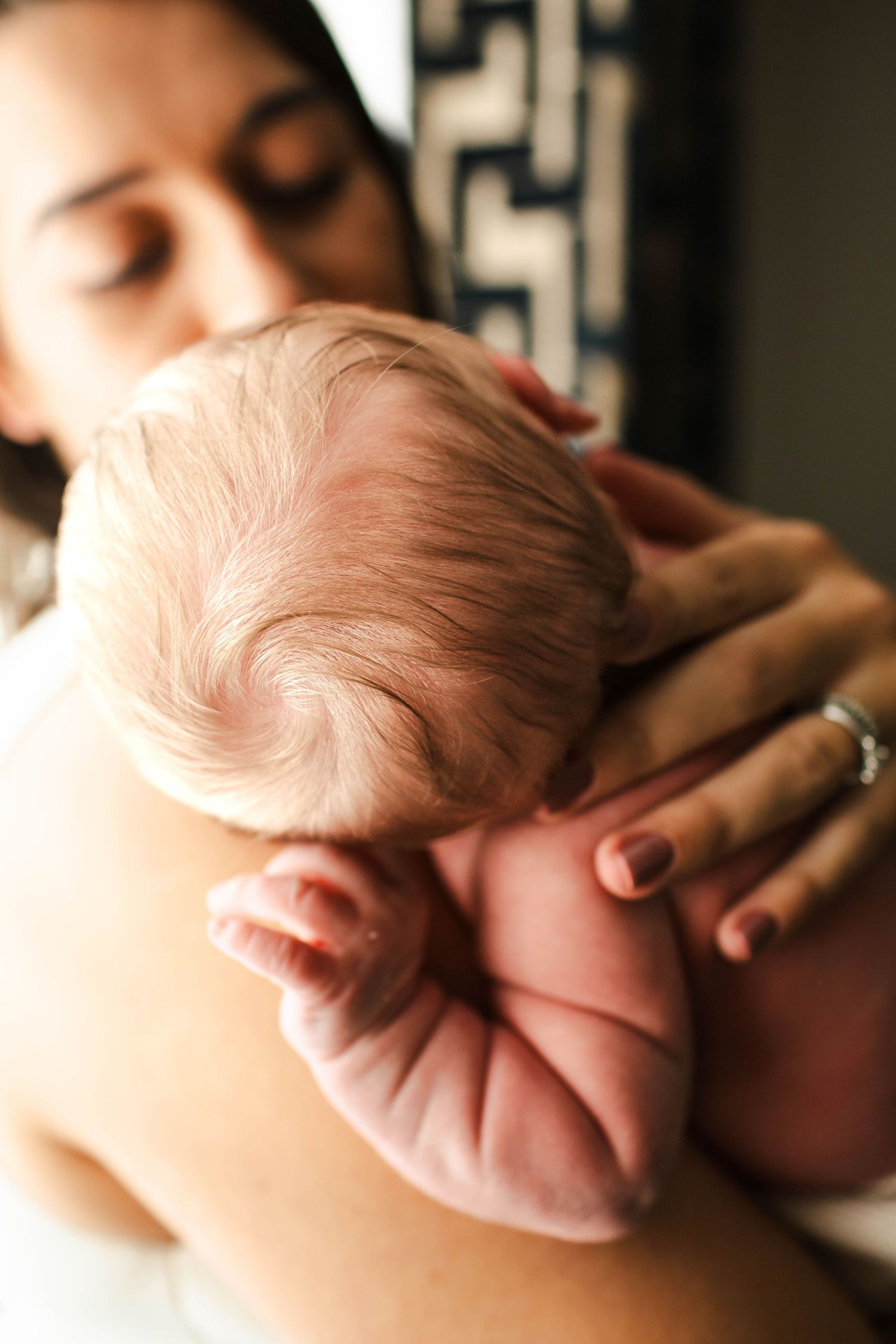 A series of close-up shots showing a sleeping newborn baby's delicate facial features and wispy hair.