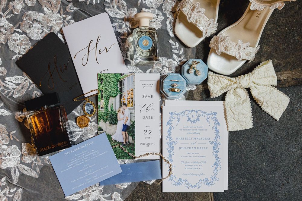 Wedding invitation suite with delicate blue floral design and lace details.