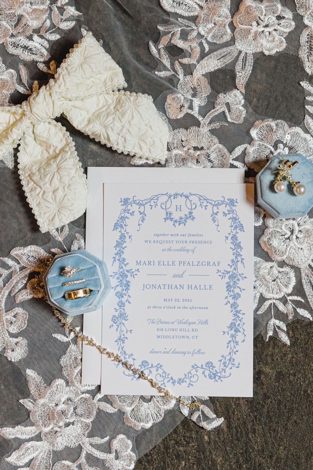 Elegant wedding stationery featuring light blue floral design on white paper with lace accents.