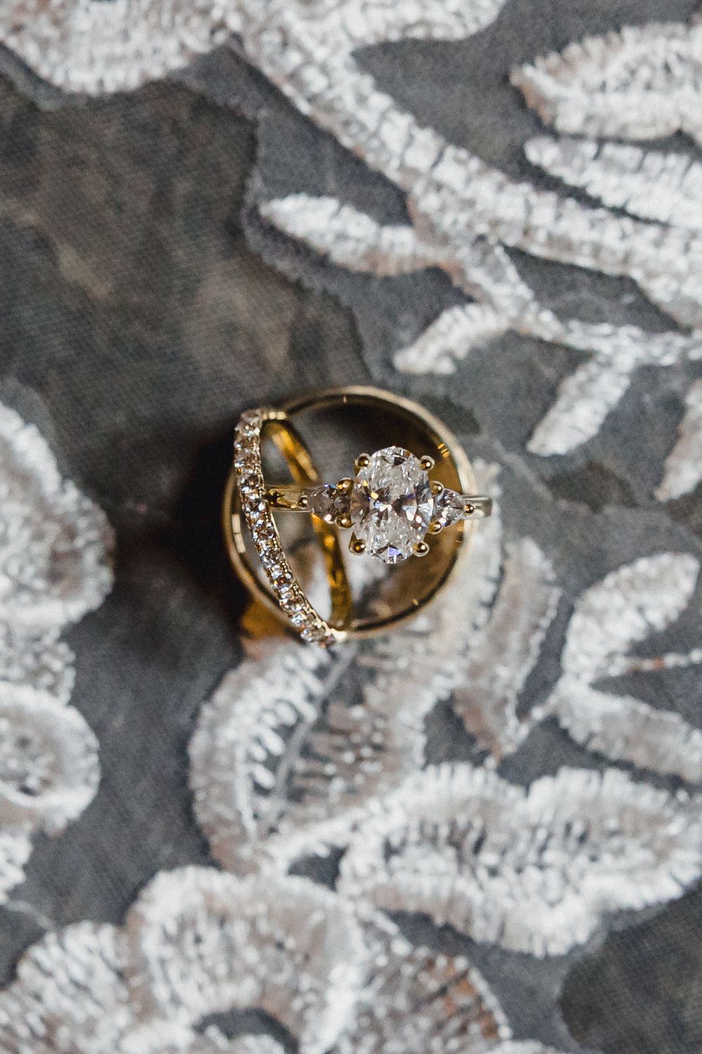 Close-up sequence showing a gold and diamond ring resting on a textured grey and white surface.