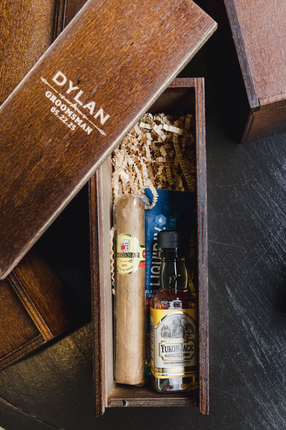 Wooden box containing champagne bottles with decorative gold details in rustic lighting.